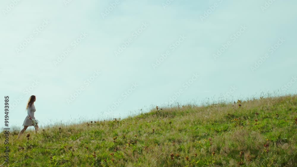 Woman Walking in the mountains with a Bouquet of Wildflowers Woman Walking in the mountains with a Bouquet of Wildflowers