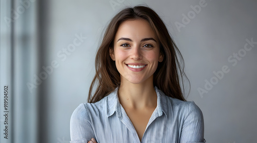 A closeup photo of a woman, age 30 wearing business attire, smiling and posing against a alight background