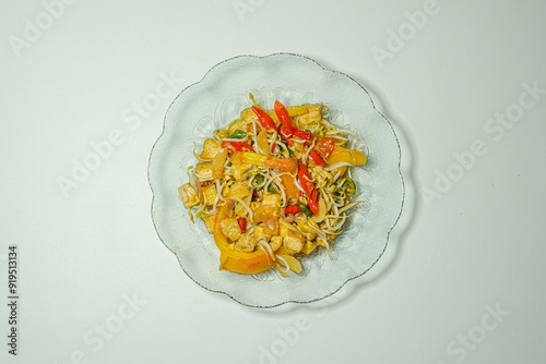 tumis cah tahu toge or stir-fried tofu and bean sprouts served on an aesthetic glass plate and with a white background, looks very delicious. photo