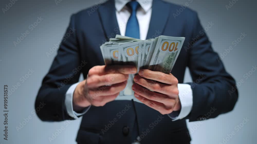 Formally dressed man is counting US Dollar bills, close-up. Formally dressed man is counting US Dollar bills, close-up.