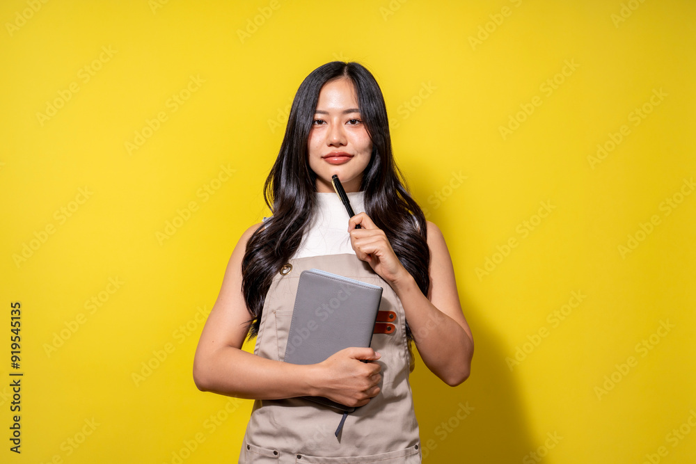 A woman is holding a book and a pen, and she is smiling A woman is holding a book and a pen, and she is smiling