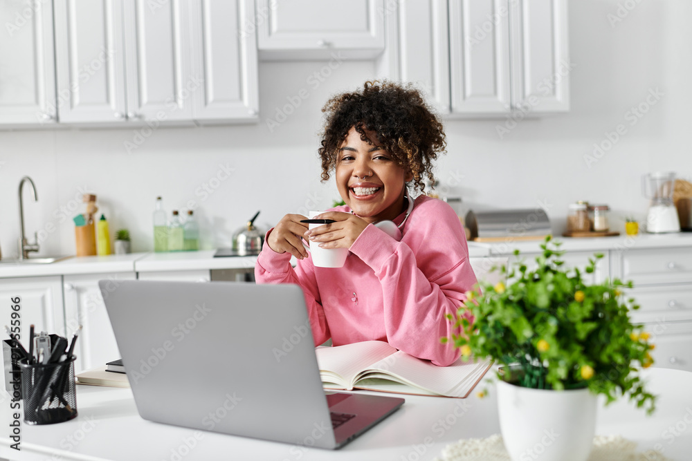 A cheerful woman relaxes at home with tea and a laptop. A cheerful woman relaxes at home with tea and a laptop.