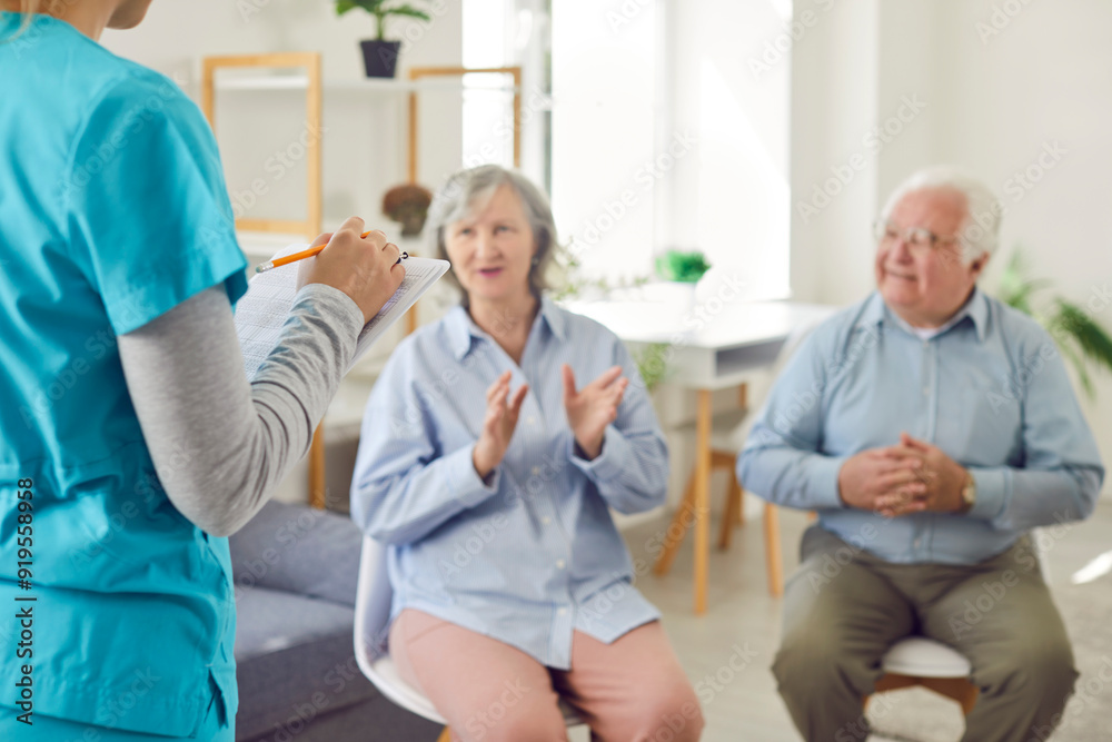 Female doctor, nurse, or caregiver talking with elderly, old patients during a meeting in the nursing home. Care, communication, and support for senior residents of retirement home. Female doctor, nurse, or caregiver talking with elderly, old patients during a meeting in the nursing home. Care, communication, and support for senior residents of retirement home.