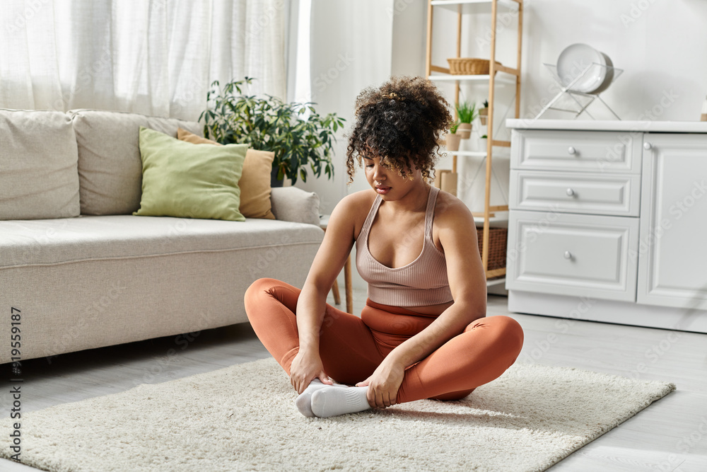 A woman stretches on the floor, enjoying peaceful moments of self care at home. A woman stretches on the floor, enjoying peaceful moments of self care at home.