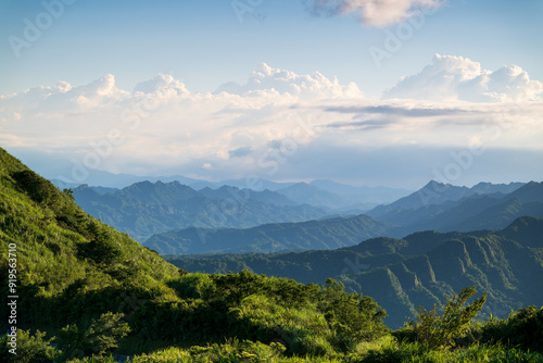 Enjoying the view of layered green mountains under a blue sky with white clouds. Captured in Jiufen, Taiwan.