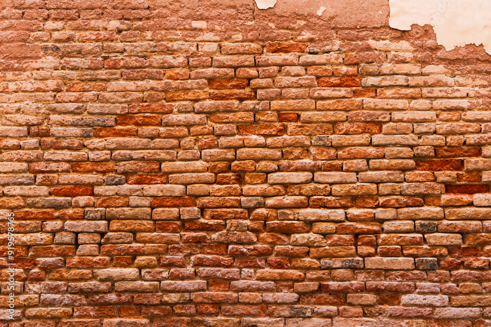 an old brick wall made of uneven, sometimes weathered and weathered bricks of varying shades from light beige to dark red. Brickwork creates a sense of history and time, conveying a warm and cozy atmo an old brick wall made of uneven, sometimes weathered and weathered bricks of varying shades from light beige to dark red. Brickwork creates a sense of history and time, conveying a warm and cozy atmo