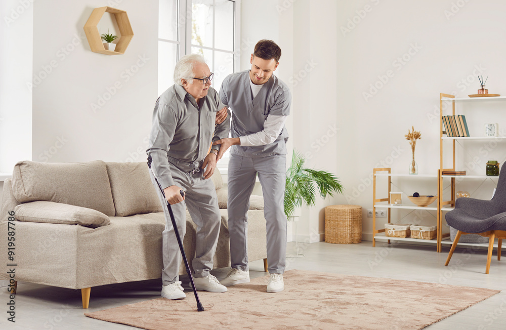 Portrait of a young nurse helping a senior patient to walk with his crutches at home. Physiotherapist helping old man in rehab. Health care worker helping an elderly man and smiling. Portrait of a young nurse helping a senior patient to walk with his crutches at home. Physiotherapist helping old man in rehab. Health care worker helping an elderly man and smiling.