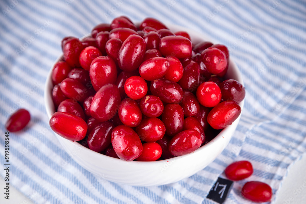Cornelian cherry, dogwoods edible berry in white bowl Cornelian cherry, dogwoods edible berry in white bowl