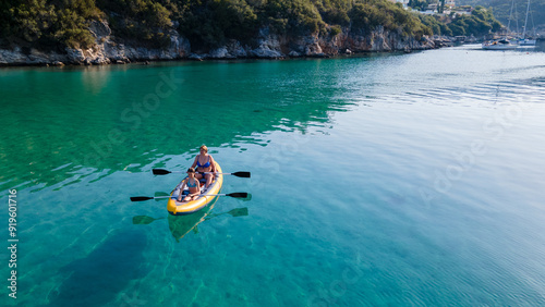 Single mother and daughter enjoying a beach day in their inflatable kayak. Active mother with daughter having fun and enjoying adventurous experience with kayak on a sunny day during summer vacation