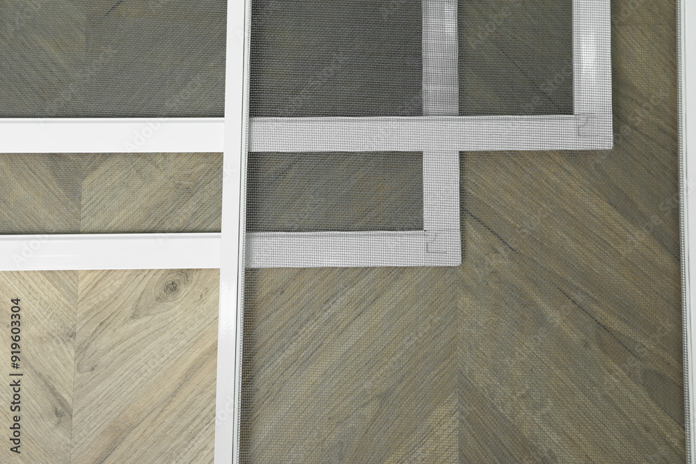 Fototapeta premium Set of window screens on wooden floor, flat lay