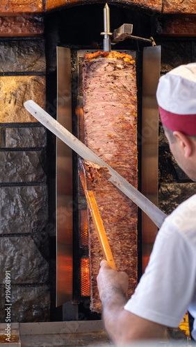 Canvas Print Chef skillfully cutting shawarma meat from a rotating skewer