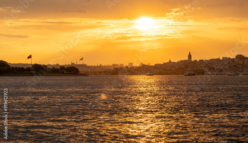 Fototapeta Naklejka Na Ścianę i Meble -  The sun sets over the Bosphorus, casting a golden glow on Istanbul's skyline