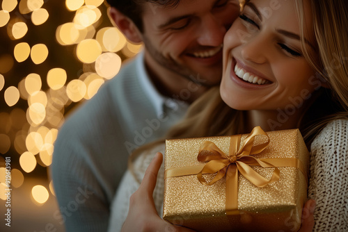 Close-Up of Couple Exchanging Gift with Golden Ribbon, Holiday Celebration and Joy photo