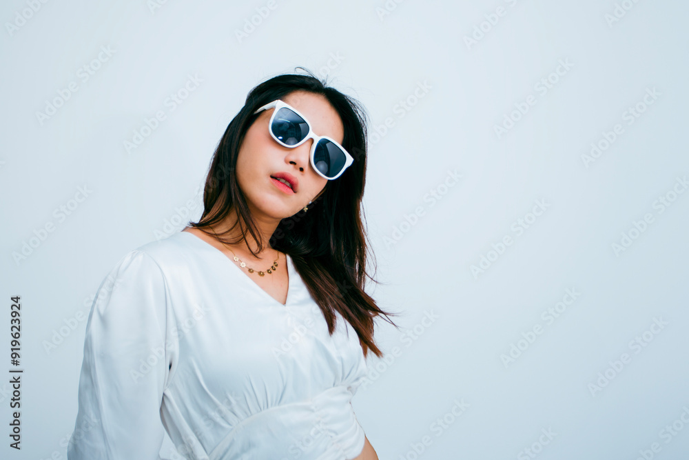 sexy young woman in sunglasses while standing floating with brown hair over white background, woman posing convincingly in white suit sexy young woman in sunglasses while standing floating with brown hair over white background, woman posing convincingly in white suit