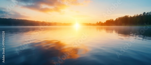  A sunset scene over a sizable water body, with trees silhouetted beyond it