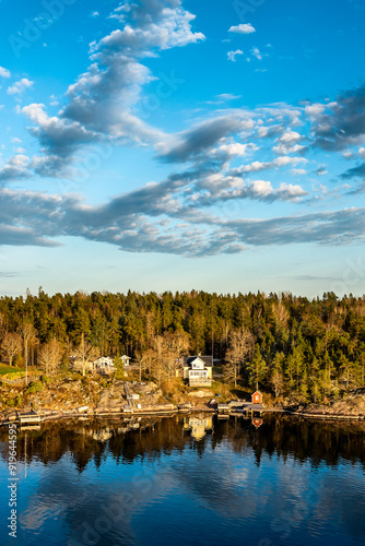 Canvas Print Small idyllic port in the Swedish archipelago outside of Stockholm with beautiful reflection lighted with sunspot at autumn evening