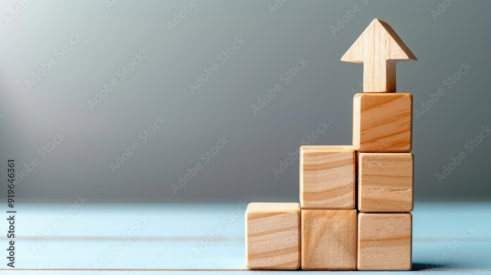 Financial progress illustrated with wooden blocks and an arrow up, business development Financial progress illustrated with wooden blocks and an arrow up, business development