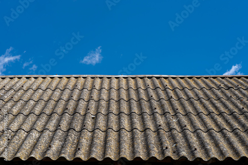 An old brick barn in the Polish countryside with a corrugated asbestos roof.