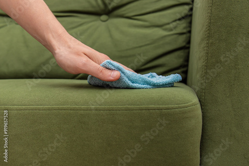 Wiping the sofa with dust cloth closeup. Professional cleaning service