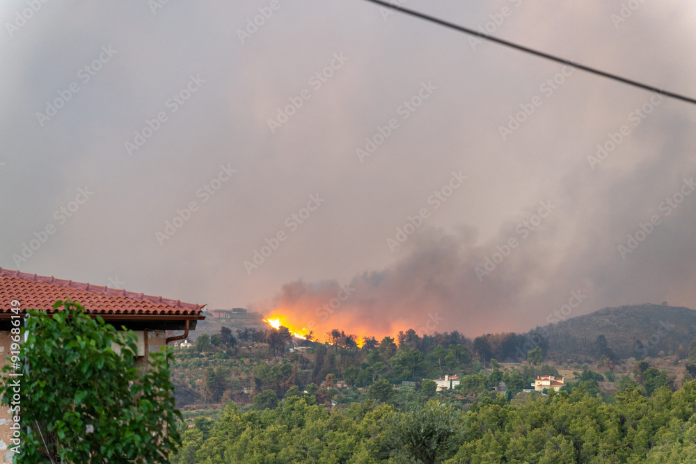 House and a forest fire in the distance