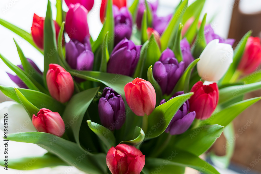 A bouquet of multi-colored tulips on the table. The concept of spring joy, celebration and freshness A bouquet of multi-colored tulips on the table. The concept of spring joy, celebration and freshness