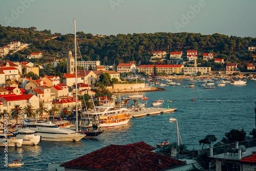 Coastal town of Hvar, Croatia with boats docked at the harbor and traditional houses at sunset
