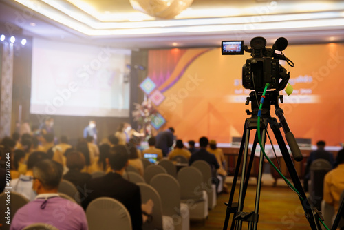 Camcorder while filming. TV camera in conference or seminar. Video camera with blur background.