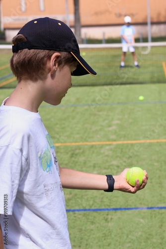 Two boys playing tennis on the local tennis court