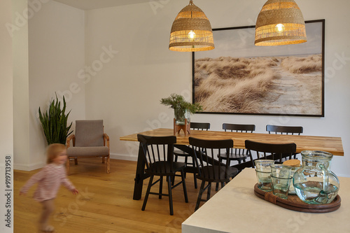 Interior of light living room with table with two celling lamps. Defocused runnig child photo