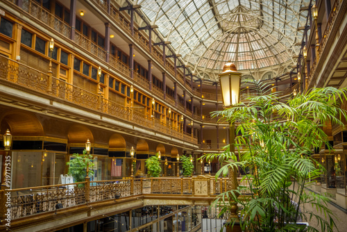 The interior of Arcade Cleveland shopping mall with famous glass skylight, an iconic landmark of Romanesque architecture that features numerous shops and restaurants.
