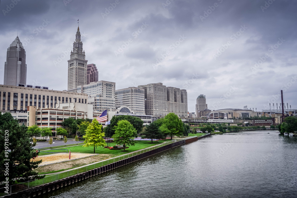 Fototapeta premium The Cleveland panorama view: Cuyahoga river waterfront with the volleyball facility, US flag, buildings, skyscrapers and American architecture. 