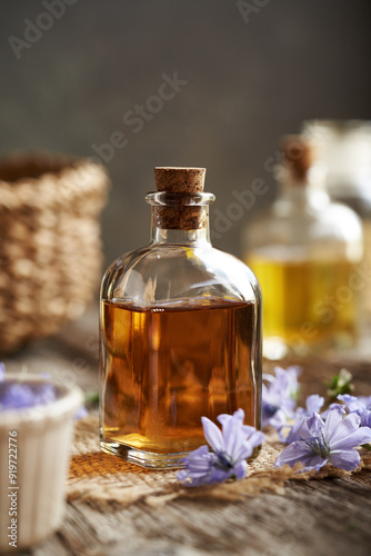 A bottle of herbal tincture with fresh chicory flowers