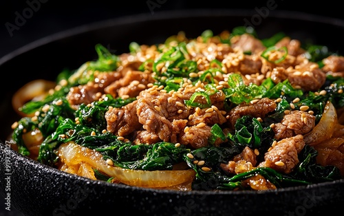 Japanesestyle stirfried beef with onions and garlic, served over a bed of sauteed spinach, garnished with shredded nori and sesame seeds photo