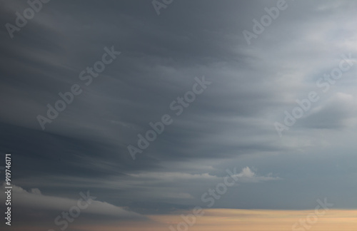 Sky replacement dark clouds over orange horizon