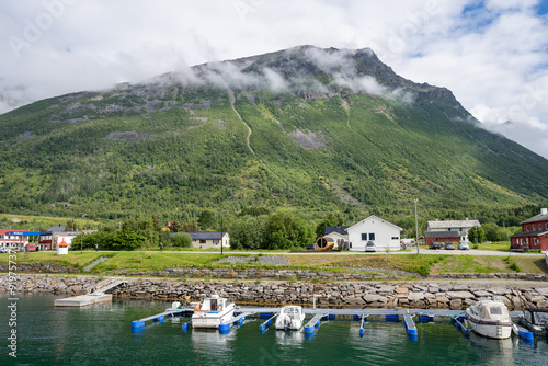 Olderdalen, Norway - 07.04.2024: Boats and yachts in Olderdalen Port with green mountain in background in Norway
