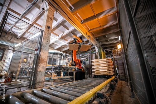modern woodworking factory interior showing stacks of wooden boards and workers in the background, organized for efficient production and storage photo