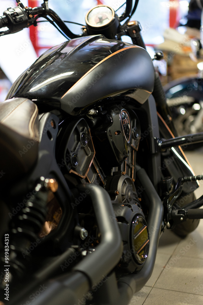 A black motorcycle parked indoors. The motorcycle is the main focus of the scene, occupying a significant portion of the space. A black motorcycle parked indoors. The motorcycle is the main focus of the scene, occupying a significant portion of the space.