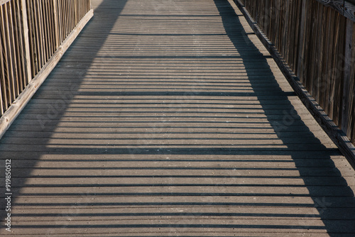 The morning sun casts long shadows across the protective boardwalk leading to the gulf beaches within Topsail Hill Preserve State Park, Santa Rosa Beach, Florida in mid-April