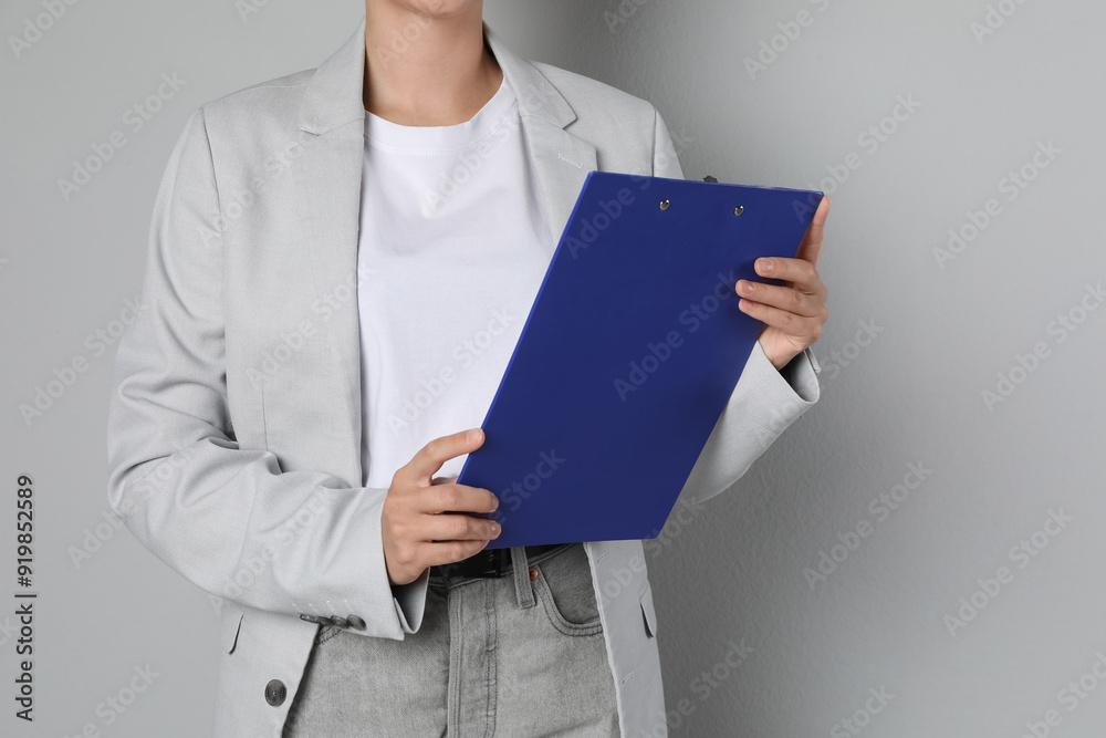 Engineer with clipboard on grey background, closeup Engineer with clipboard on grey background, closeup