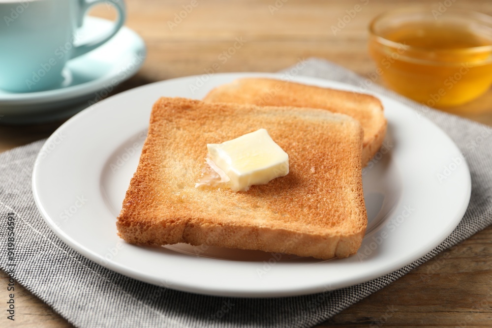 Delicious toasted bread slices with butter on wooden table, closeup Delicious toasted bread slices with butter on wooden table, closeup