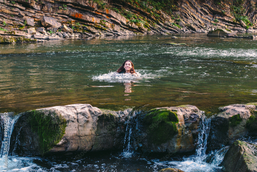Fototapeta premium Beautiful young woman in river in Carpathian mountains