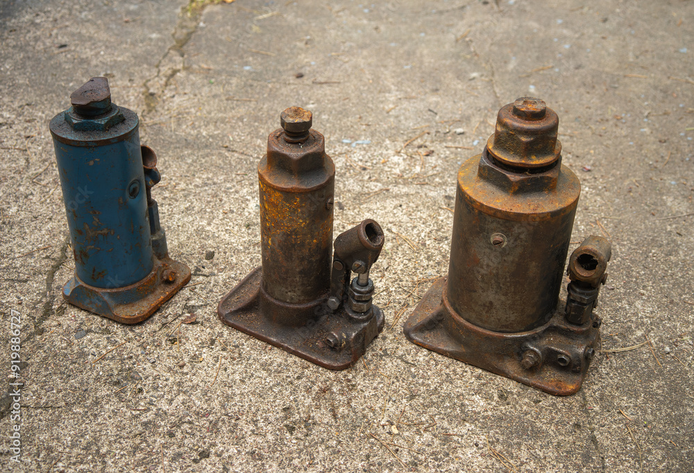 Old hydraulic jacks.Lift a heavy load with a jack.A rusty vintage cargo lifting tool. Old hydraulic jacks.Lift a heavy load with a jack.A rusty vintage cargo lifting tool.