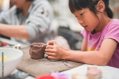 Canvastavla Young girl deeply engrossed in shaping clay during an art project