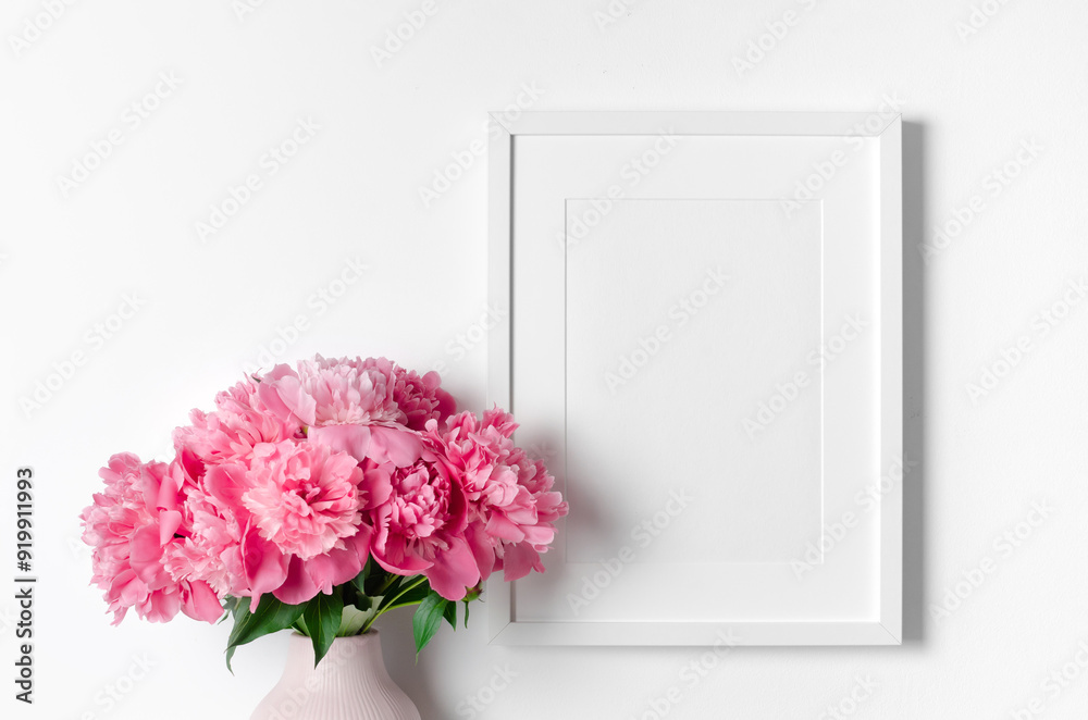Blank white frame mockup with pink peony flowers, mockup with copy space for artwork presentation Blank white frame mockup with pink peony flowers, mockup with copy space for artwork presentation