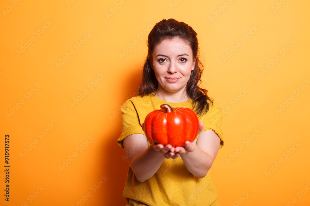 Portrait of a healthy woman grasping a red bell pepper. Positive female vegan and organic nutritionist displaying fresh raw vegetables and presenting a vegetarian diet with vitamins. Portrait of a healthy woman grasping a red bell pepper. Positive female vegan and organic nutritionist displaying fresh raw vegetables and presenting a vegetarian diet with vitamins.