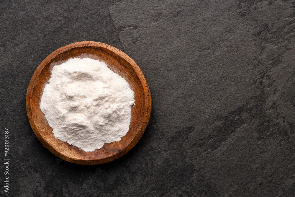 Baking soda in bowl - Healthy food. Green background Baking soda in bowl - Healthy food. Green background