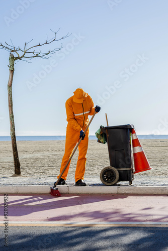 Homem varrendo a praioa, ecologicamente correto, sos mundo photo