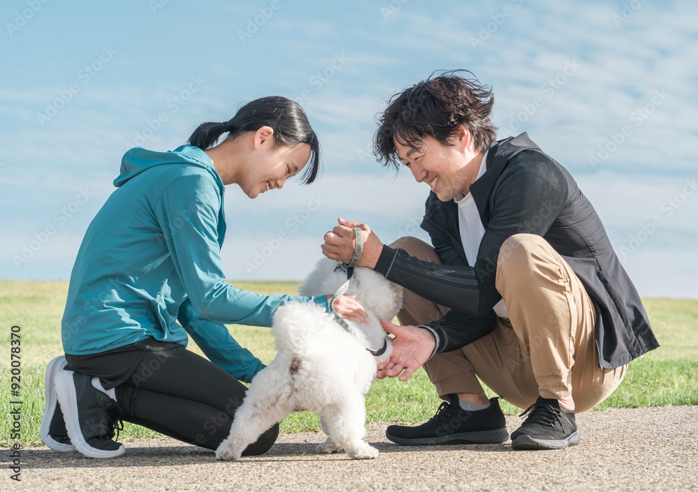 公園で犬と遊ぶ親子・犬の散歩・運動
