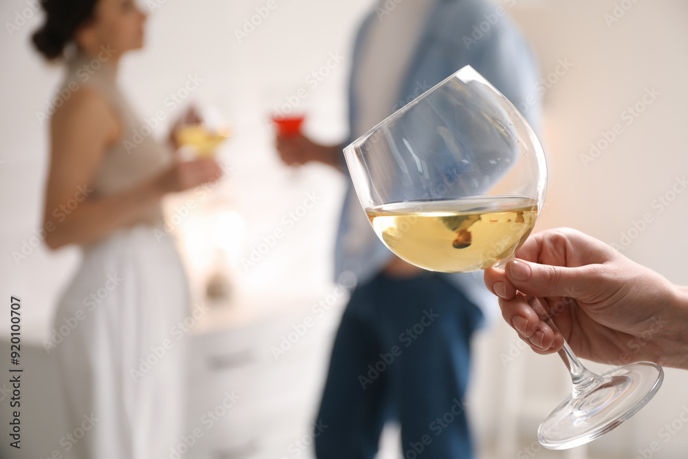Woman with glass of wine indoors, selective focus