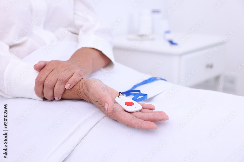 Senior woman with emergency call button on bed in hospital, closeup Senior woman with emergency call button on bed in hospital, closeup